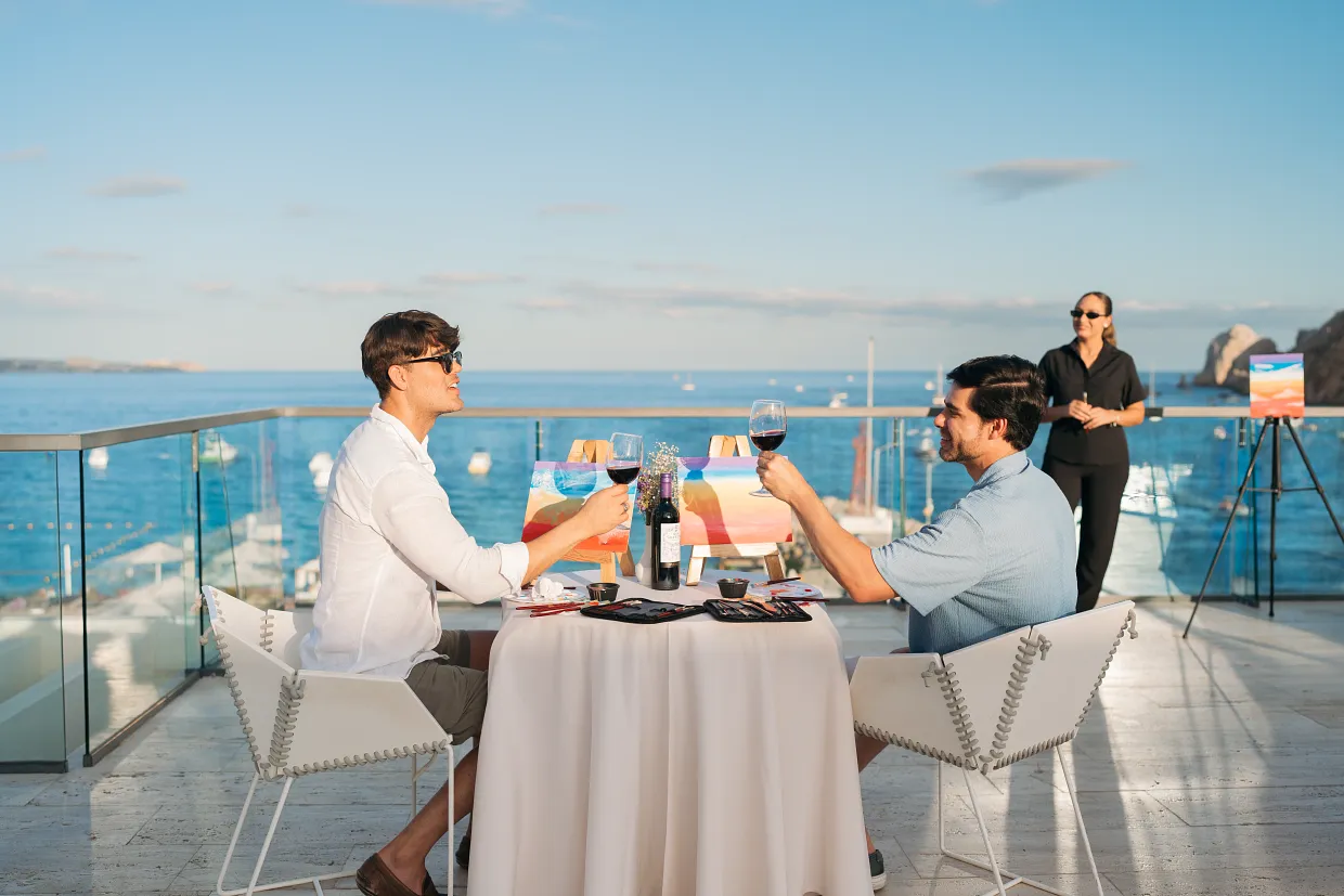 Guests enjoying an oceanfront sip and paint activity at Breathless Cabo San Lucas.