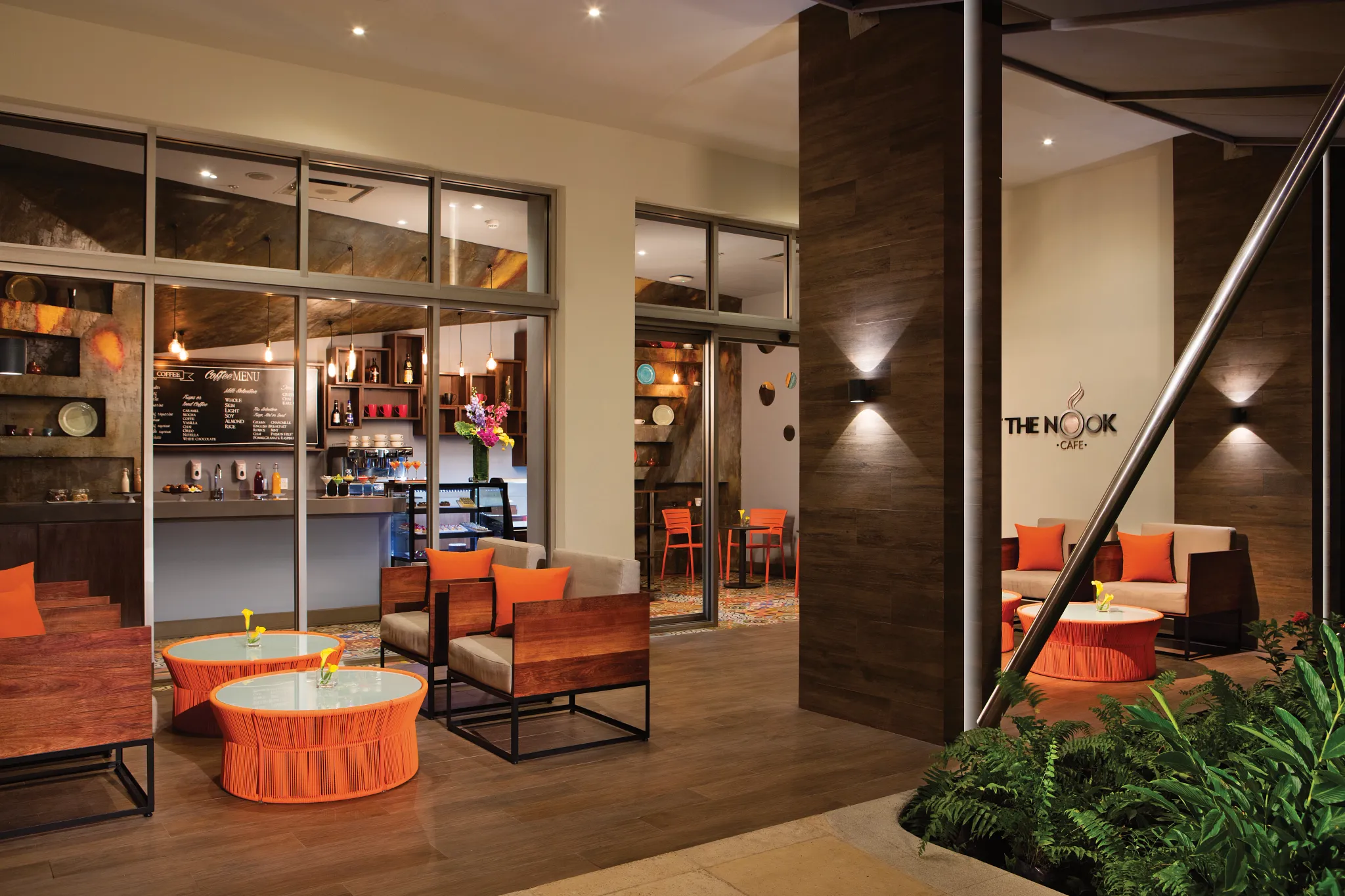 The Nook Café at Breathless Riviera Cancun featuring cozy seating, warm lighting, modern wood accents, and a coffee counter.