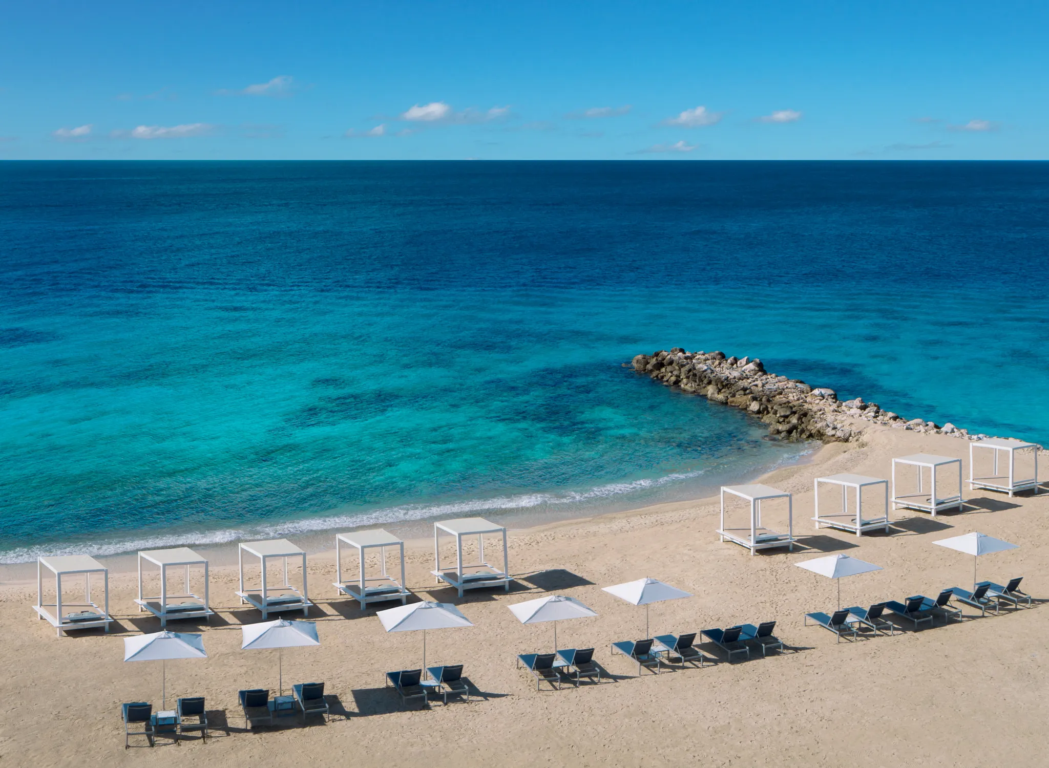 Oceanfront beach cabanas overlooking crystal-clear turquoise waters at Zoëtry Curaçao Resort & Spa, offering a serene luxury beach experience.