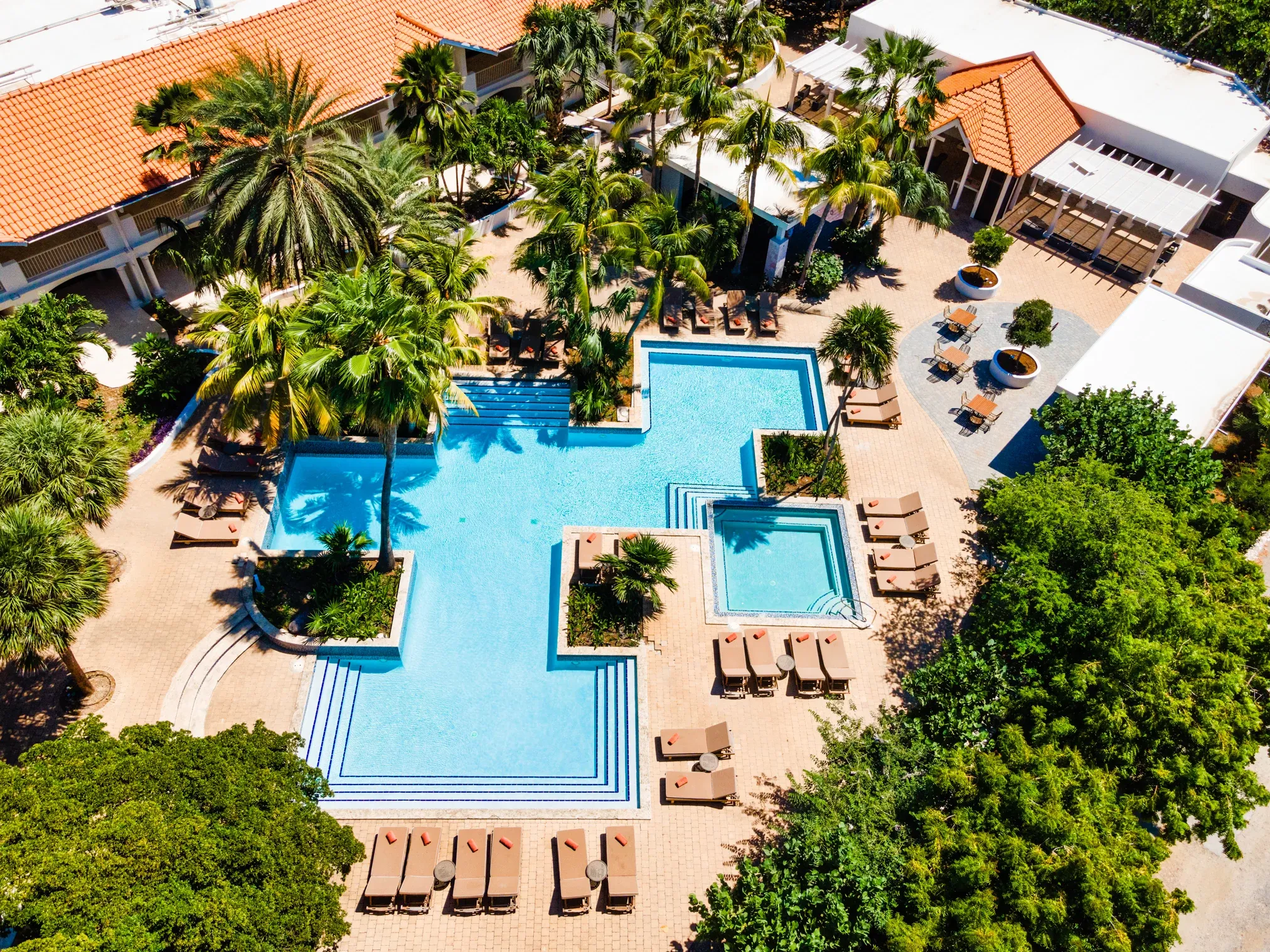 Aerial view of the central pool and tropical grounds at Zoëtry Curaçao Resort & Spa, showcasing the resort’s intimate luxury design.